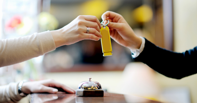 Hotel Guest Receiving Room Key from Front Desk