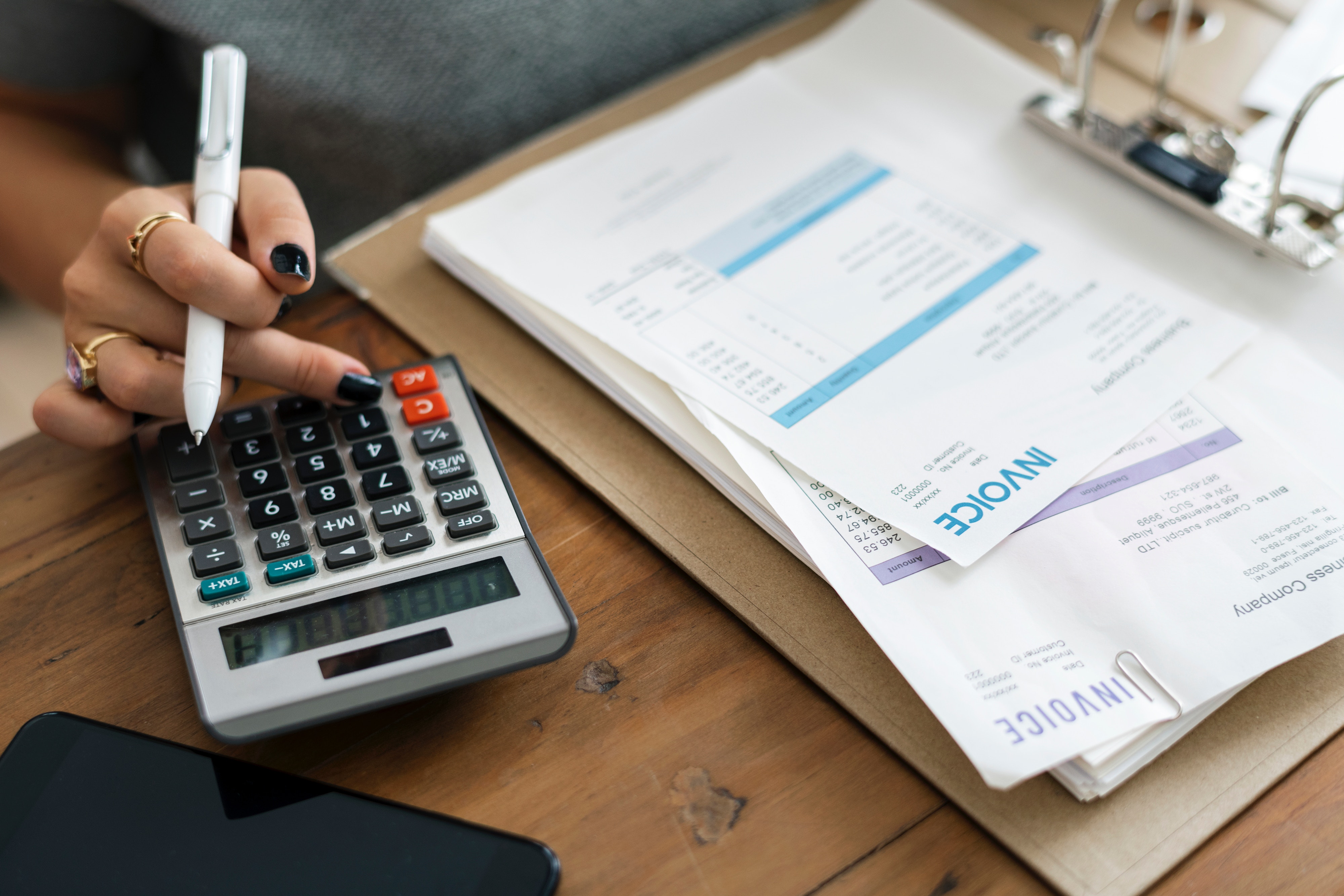 Woman with invoices and calculator.