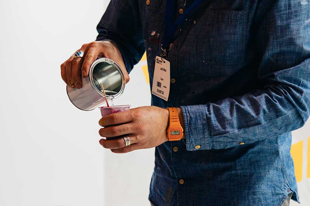 man with work ID badge pouring coffee
