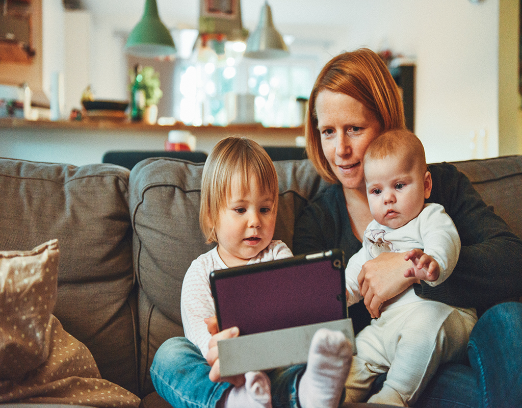 Mother watching tablet with children.
