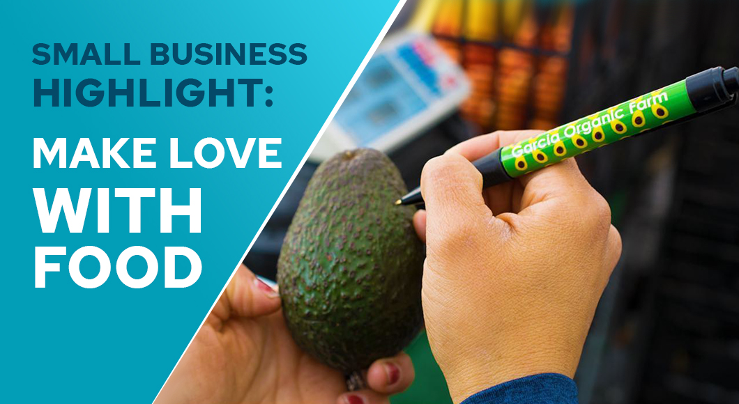 hand holding avocado themed promotional pen with logo, writing on organic avocado