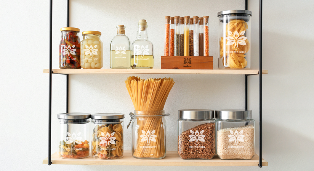 Products on shelves in a retail store reflecting rebranding of a small business including logo on jars, tubes, and wooden containers.