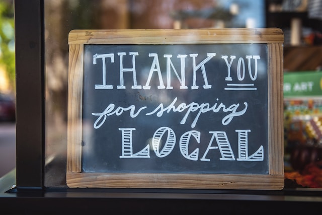 Shop local chalkboard sign in small business store window