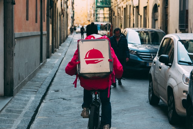 Delivery person riding bike.