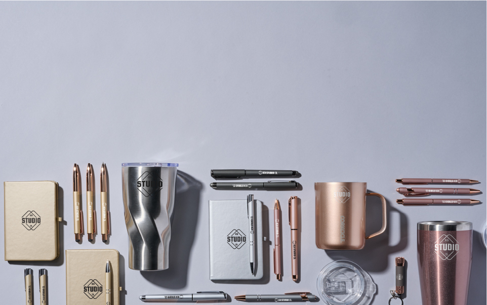 Mineral Collection - a variety of promotional products with metallic colors from gold to silver is on display. Mugs, tumblers, pens and notebooks can be imprinted with a company logo.