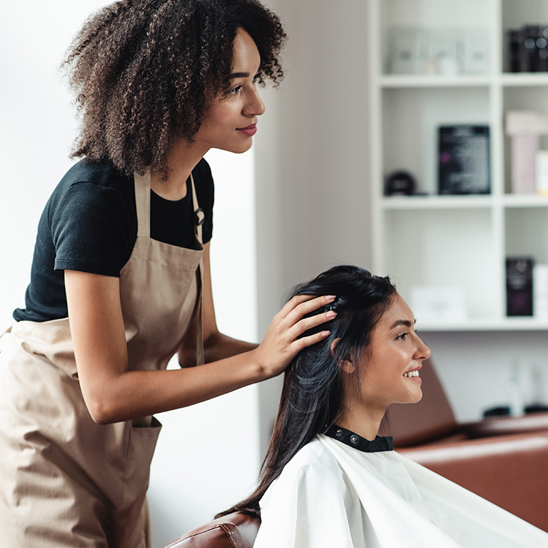 Eine Frau, die sich in einem Friseursalon die Haare waschen lässt