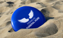 Frisbee nella sabbia con logo personalizzato di un’agenzia funebre