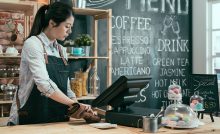 Commerciante impegnata a digitare sullo schermo della cassa